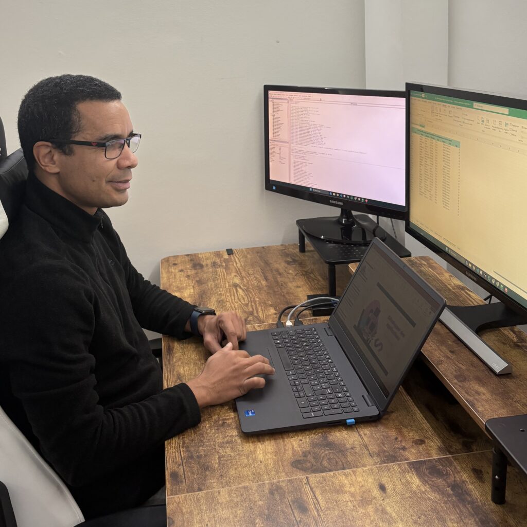 Rodrigue CALIMIA assit à son poste de travail